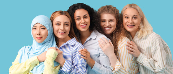 Fototapeta premium Group of beautiful women hugging on blue background. Women's History Month