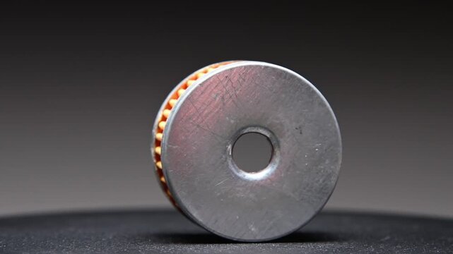 New car parts. A new LPG gas reducer filter rotates on a black gradient background