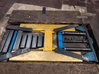 Empty car lift in a repair shop waiting for vehicle maintenance