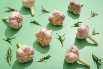 Fresh garlic with rosemary on green background
