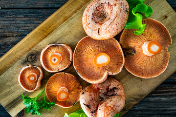 Raw saffron milk cap mushrooms on wooden table. Top view