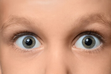 Naklejka premium Surprised little boy with green eyes, closeup