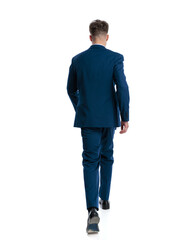 Fototapeta premium behind view of elegant fashion man in navy blue suit moving forward