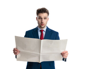 happy elegant man in navy blue suit reading newspaper and looking forward