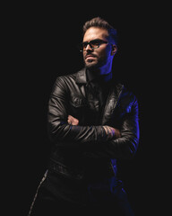 sexy cool man with sunglasses looking away and posing while folding arms