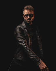 Fototapeta premium cool dramatic man with sunglasses in black leather jacket posing