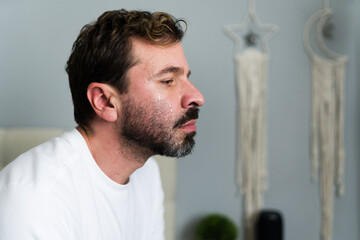 Profile view of a man crying after breakup in bedroom