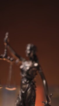 vertical video of bronze law statue represented by blindfolded goddess holding a balance signifying impartiality and two broad sources of law 