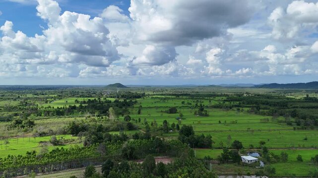 The sequence of images depicts a vast, lush landscape characterized by expansive green fields and scattered patches of trees under a partly cloudy sky