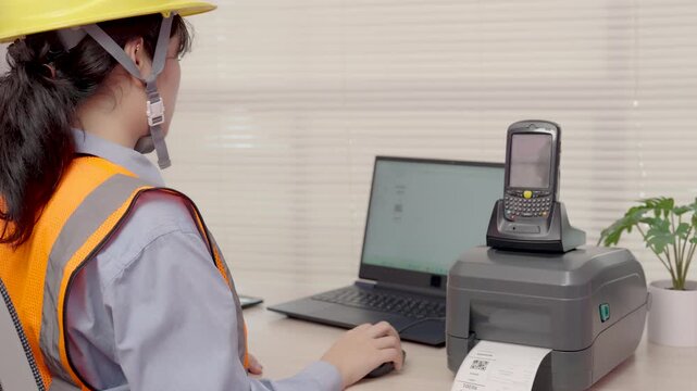 Beautiful Asian woman uses a laptop or notebook to print bar code stickers on a bar code printer.