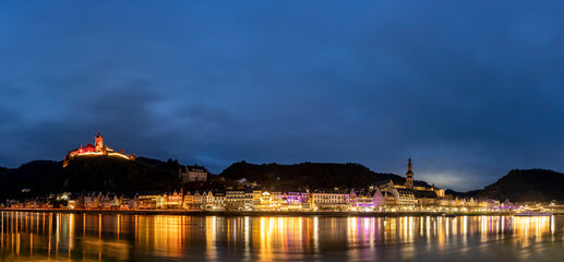 The picturesque town of Cochem, Germany, glows at night in the heart of the Moselle Valley. Cochem offers a magical blend of medieval charm, vineyard