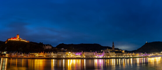 Fototapeta premium The picturesque town of Cochem, Germany, glows at night in the heart of the Moselle Valley. Cochem offers a magical blend of medieval charm, vineyard