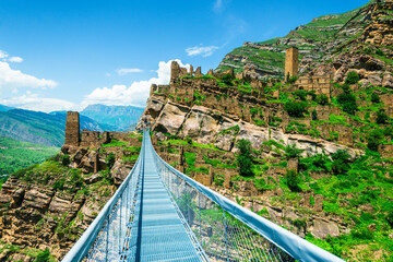 Modern mountain suspension bridge leading to the ruins of the village of Kakhib. North Caucasus