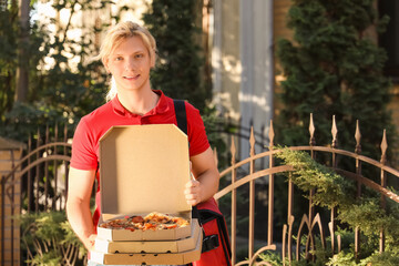 Male courier with pizza boxes outdoors