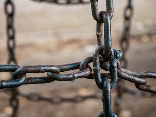 Close up of old rusty metal chain links with corrosion and weathered surface texture showing age and deterioration