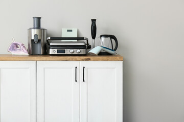Different household appliances on counter against white wall