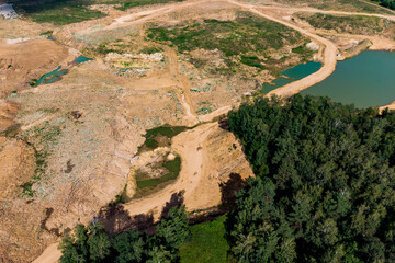 Aerial view of an expansive sand quarry, featuring vast excavated earth, various green water...