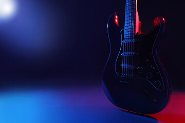 Modern electric guitar on colorful background, closeup