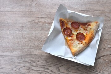 piece of baking homemade peperoni pizza topping slice salami on paper in plate 
