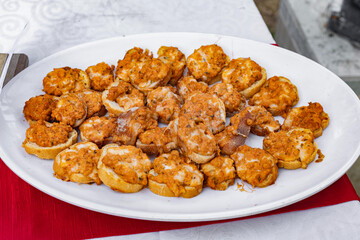 Delicious appetizers with toasted bread and a flavorful topping on a white platter