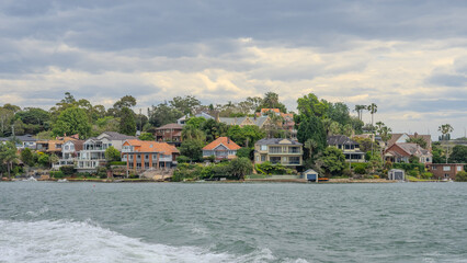 Residential Houses and apartment buildings on Parramatta River Sydney Harbour on a warm spring cloudy overcast day in Sydney NSW Australia