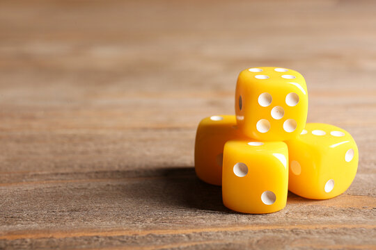 Yellow dices on wooden background
