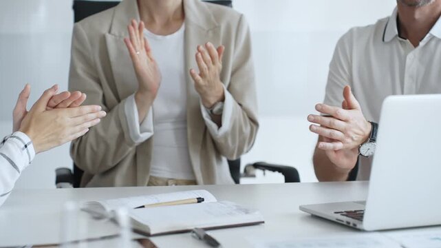Business team applauding after achieving a goal during a productive meeting in a modern office environment, celebrating success and teamwork, close up