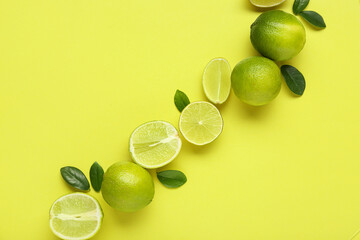 Fresh ripe limes and leaves on green background