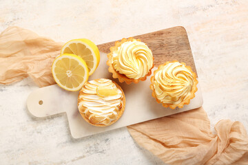 Tasty lemon tartlets on light background
