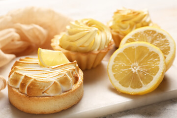 Tasty lemon tartlets on table
