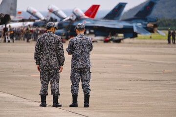 駐機している戦闘機の列の手前の二人の隊員