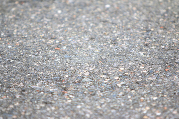 Granular Pavement Texture: A detailed, close-up view of rough granular asphalt pavement, revealing a rich texture perfect for conveying concepts of urban landscapes or industrial settings. 