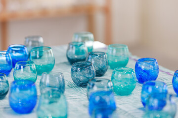 Table Display of Ryukyu Glass in Ocean Colors with Natural Light Background(海色の琉球グラスの並ぶテーブルと自然光の背景）