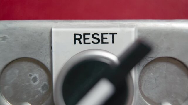 Turning a reset knob on a red wall