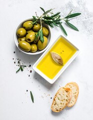 Fresh Green Olives Olive Oil Bread and Branches on White Background.