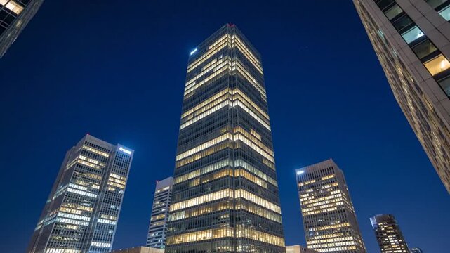 Dynamic Low-Angle Time-Lapse of Illuminated Corporate Skyscrapers Against a Starry Night Sky