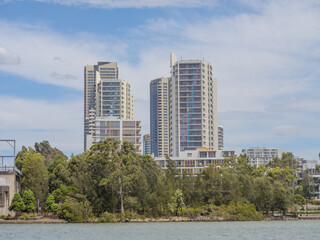 Fototapeta premium Residential Houses and apartment buildings on Parramatta River Sydney Harbour on a warm spring cloudy overcast day in Sydney NSW Australia 