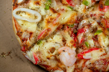 Fine art macro shot highlighting the rich surface texture of Italian-style seafood pizza, showing cheese bubbles and crispy crust.