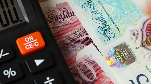  United Kingdom finances. Calculator and money counting. British pounds. UK business concept, expense analysis, taxes, cost accounting