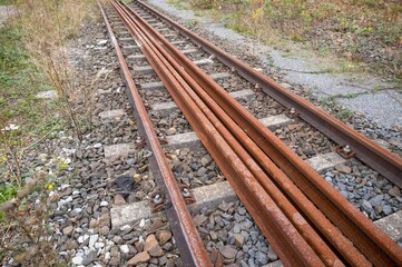 Fototapeta premium Abandoned rusty railway tracks with new rails waiting