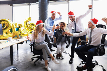 Business people are celebrating holiday in modern office drinking champagne and having fun in coworking. Merry Christmas and Happy New Year 2026