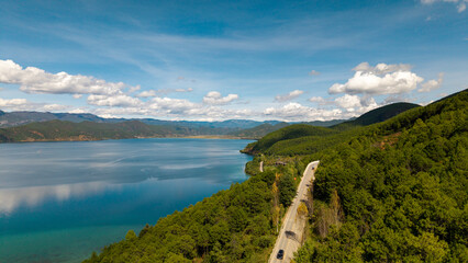 Villages by the Sunrise Lake and distant mountains, Lugu Lake in Sichuan, China
