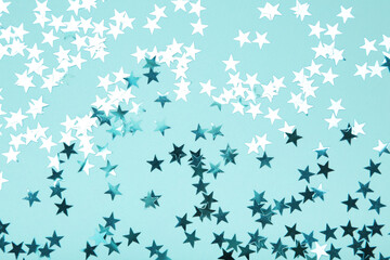 Blue glitter stars on blue background. Space for text