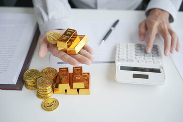 Gold Trading Businessman invest in trading gold, calculating profit price of gold in stock market...