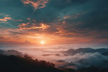 Fototapeta premium Sunrise over misty mountains, clouds painted with orange light creating a serene landscape. Tranquil scene with rolling hills and soft hues.