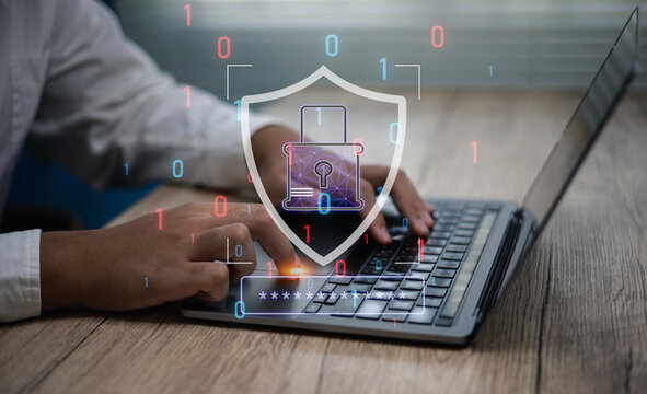 Cybersecurity concept, businessman using laptop protected by digital shield binary code overlay, representing online data protection, network safety, and privacy technology for business security