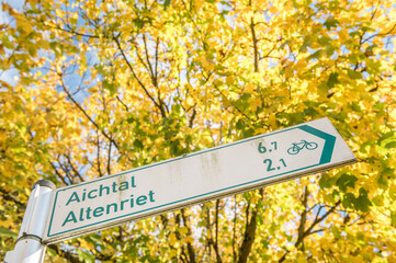 Wegweiser Radweg Altenriet Aichtal am Neckartalradweg von Neckartenzlingen über Reutlingen-Mittelstadt nach Tübingen vor Ahornbaum mit buntem Herbstlaub.