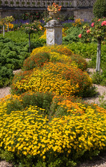 vasque fleurie dans une allée d'un jardin ornemental, allée dans un jardin à la française, jardin topiaire