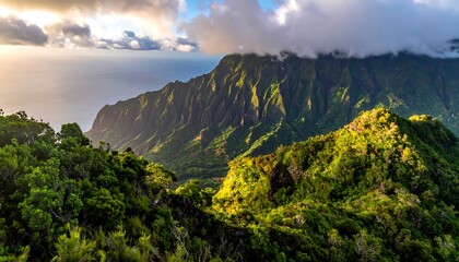 A lush, sun-drenched mountain landscape meets the ocean beneath a cloudy sky. Green vegetation and cliffs cascade towards the sea