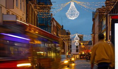 Classic red double-decker bus on festive London street at night